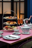 Una mesa rosa con comida y copas de vino. en The Savoy Hotel, en Limerick