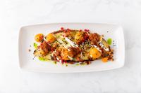 a white plate with a fish dish on a table at Kimpton Everly Hotel Hollywood by IHG in Los Angeles