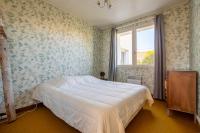 a bedroom with a bed with floral wallpaper and a window at Nature et decouverte a Brem sur Mer in Brem-sur-Mer