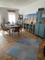 a living room with a table and chairs and a kitchen at Appartement la corde a linge Gruissan village avec terrasses in Gruissan