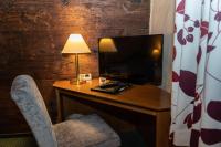 a room with a desk with a television and a chair at Ringhotel Schlossberg in Neustadt