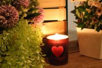 a candle with a heart on it next to flowers at T-Life Hostel in Longjing