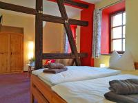a bedroom with two bunk beds with red walls at Landhotel Edelhof in Uhlstädt