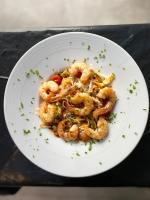 a white plate of shrimp on a black table at Vila Europa in Struga