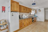 a kitchen with wooden cabinets and a white refrigerator at Maison de 4 chambres avec jardin clos a Nevez a 1 km de la plage in Névez