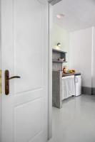 a white door in a kitchen with a table at Coralli Seaside Resort in Livadakia