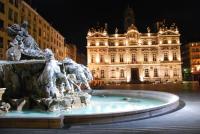 a fountain in front of a building at night at Appartement atypique au coeur des Alpes in Barraux