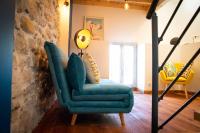 a living room with a blue chair and a lamp at Appartement atypique au coeur des Alpes in Barraux