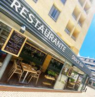 a restaurant with tables and chairs outside of it at Hotel Apartamento Foz Atlantida in Monte Gordo