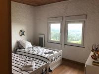 a bedroom with two beds and two windows at LA PETITE MESANGE in Dabo