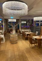 un restaurante con una gran lámpara de araña, mesas y sillas en Hallstatt Dachstein Inn, en Gosau