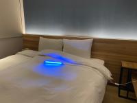 a blue light sitting on top of a bed at Muzik Hotel - Ximen Station Branch in Taipei