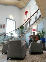 una sala de estar con una escalera con sillas y mesas. en VTF Le Domaine Les Hautannes, en Saint-Germain-au-Mont-dʼOr