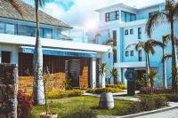 a building with palm trees in front of it at Mythic Suites & Villas by MJ Holidays in Grand Gaube