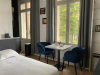 a bedroom with a table and two chairs and a bed at Le Select Studio in Dieppe