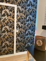 a room with a wall with blue and gold wallpaper at Le Select Studio in Dieppe