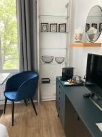 a room with a blue chair and a desk with a television at Le Select Studio in Dieppe