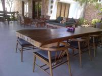 une grande table en bois avec des chaises et un canapé dans l'établissement Villa Bukit Segara, à Amed