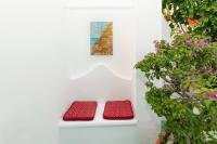 two red benches sitting on a white wall with flowers at Casa Teresa in Positano