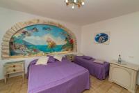 a bedroom with two beds and a painting on the wall at Casa Teresa in Positano