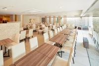 a restaurant with wooden tables and white chairs at HOTEL MYSTAYS Yokohama in Yokohama