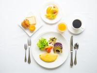 a table with a plate of food and a cup of coffee at Miyakojima Tokyu Hotel & Resorts in Miyako Island