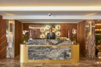 a man in a suit standing behind a marble counter in a lobby at Grand Hotel Gulsoy Old City in Istanbul