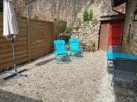 two blue chairs and an umbrella and a fence at L&#39;Arbois 1876-La Verrière- in Arbois