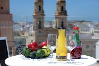 a table with two wine glasses and a bowl of fruit at Plaza Mina Suites - Adults Recommended by Luxury Suites Cadiz in Cádiz