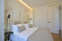 a bedroom with a large bed with white sheets and pillows at Plaza Mina Suites - Adults Recommended by Luxury Suites Cadiz in Cádiz