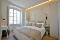 a white bedroom with a large bed and a window at Plaza Mina Suites - Adults Recommended by Luxury Suites Cadiz in Cádiz