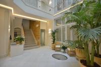 a hallway with stairs and potted plants in a building at Plaza Mina Suites - Adults Recommended by Luxury Suites Cadiz in Cádiz