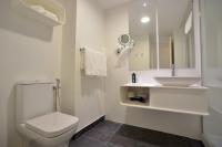 a white bathroom with a toilet and a sink at Plaza Mina Suites - Adults Recommended by Luxury Suites Cadiz in Cádiz