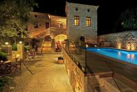 a villa with a swimming pool at night at Archontiko Chioti in Leonidion