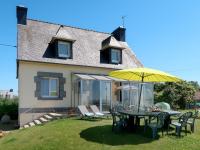 a table and chairs with an umbrella in front of a house at Holiday Home Les Hortensias - KSD101 by Interhome in Kermaria-Sulard