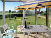 a table with an umbrella and two chairs at Holiday Home Les Hortensias - KSD101 by Interhome in Kermaria-Sulard