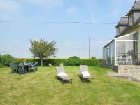 a yard with chairs and a table and a house at Holiday Home Les Hortensias - KSD101 by Interhome in Kermaria-Sulard