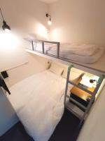 two bunk beds in a small room with a bed at Inn Cube - Taipei Main Station in Taipei