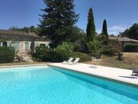 a swimming pool with two chairs and a house at L&#39;Olivier in Puisseguin