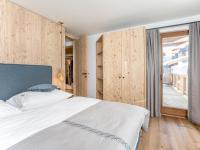 a bedroom with a large bed and wooden walls at Haus Widmann in Fieberbrunn
