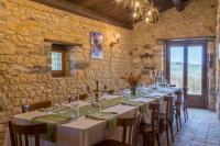 uma sala de jantar com mesas e cadeiras e uma parede de pedra em Masseria Fortificata Lo Zafferaneto em Buccheri