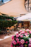 a bunch of pink flowers on a patio with tables and chairs at Hotel Restaurant Nöth in Hammelburg