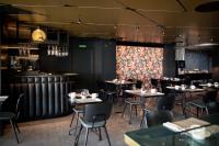 Un restaurante con mesas y sillas y un bar. en Silken Saaj Las Palmas, en Las Palmas de Gran Canaria