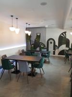 Un comedor con mesas y sillas verdes. en PENSIUNEA ADA, en Bascov