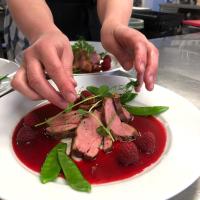 a person reaching for meat on a plate of food at Snöå Bruk Hotell och konferens in Dala-Järna