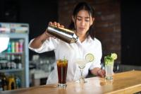 a woman is making a drink at a bar at Hotel Tungurahua in Baños