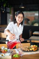 a woman is standing at a table preparing food at Hotel Tungurahua in Baños
