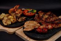 two black plates of food with meat and vegetables at Hotel Tungurahua in Baños