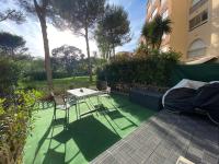 a patio with a table and chairs on a green lawn at Boost Your Immo Six Fours Les Plages Pinèdes Aryana 477 in Six-Fours-les-Plages