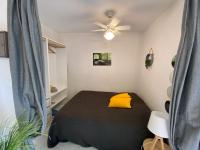 a bedroom with a black bed with a yellow pillow at Boost Your Immo Six Fours Les Plages Pinèdes Aryana 477 in Six-Fours-les-Plages
